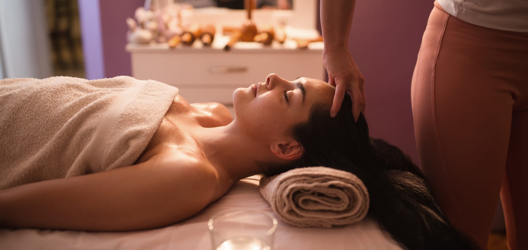 Massaggio alla testa in un centro benessere, persona rilassata su lettino con asciugamano